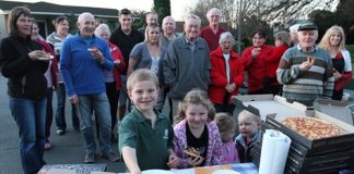 Devon St residents Tyler Burke, 8, with his sister Stevie, 6, grab some pizza as part of the street party held with their neighbours last week. Photo: Andrew Board.