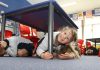 Schools prepare for Shakeout Enner Glynn student Ava Frater, 5, takes cover under a desk as her class practices for the nation-wide Civil Defence Shakeout on September 26. Photo: Andrew Board.