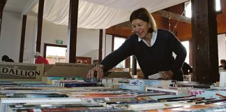 Founders Book Fair organiser Karen Clark sorts through some of the thousands of books donated for this year’s fair, which opens this Saturday. Photo: Andrew Board.