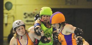 Sirens of Smash player Cherie Drummond, aka Credit Crunch, battles members of Wellington’s Richter City Convicts during Saturday nights game. Photo: Sinead Ogilvie.