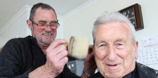 Barber Larry Sutherland cutting Les Sangster hair last week, 50 years after he cut it for the first time. Photo: Andrew Board.