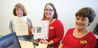Karen Dickerson, Louise Gribbon and Cathy Vaughan with the Roll of Honour of soldiers from the Nelson-Tasman region who died in World War I which has been digitised and posted online. Photo: Simon Bloomberg.