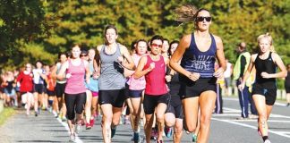 The 300 strong competitors take off at the start of the McFadden McMeeken Phillips Nelson Women's Triathlon in the Maitai Valley on Sunday. Insert: Hannah Straker, of Nelson, enjoying her run during the triathlon. Photos: Marc Palmano/shuttersport.co.nz.