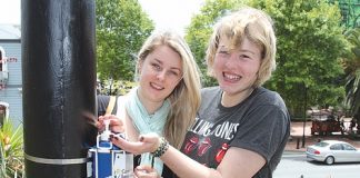 Claudia Hagerty and Jess Moser take advantage of the sunscreen put up on the cathedral steps over summer by the Cancer Society. Photo: Jessie Johnston.