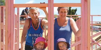 Tyrell and Nyssa Archibald with twin daughters, Dakota and Sienna, inside the framing of their new house being constructed by builders who have donated their time to help build it for the family. Photo: Monique Bergman.